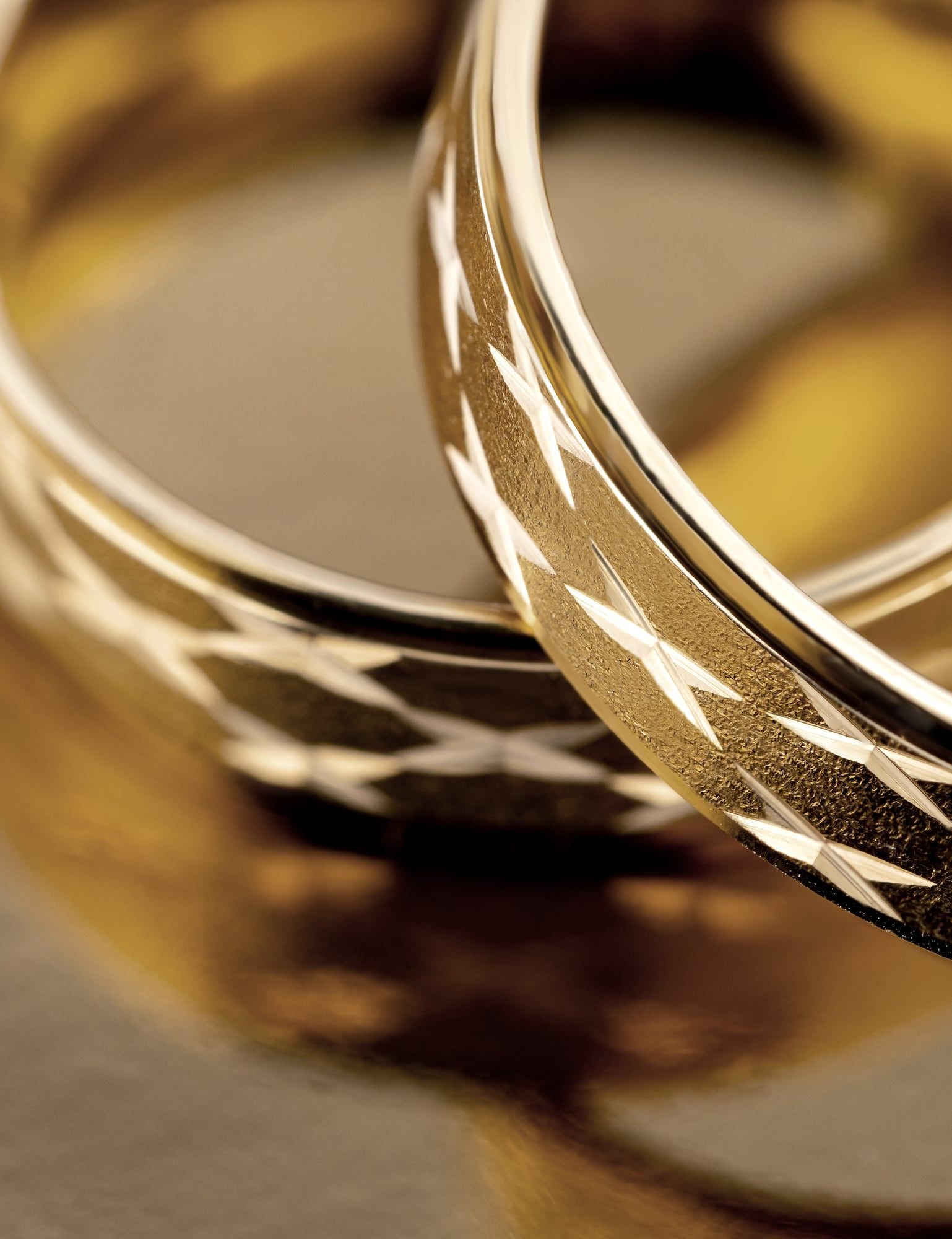 Złote obrączki z diamentowanym szlifem — zbliżenie